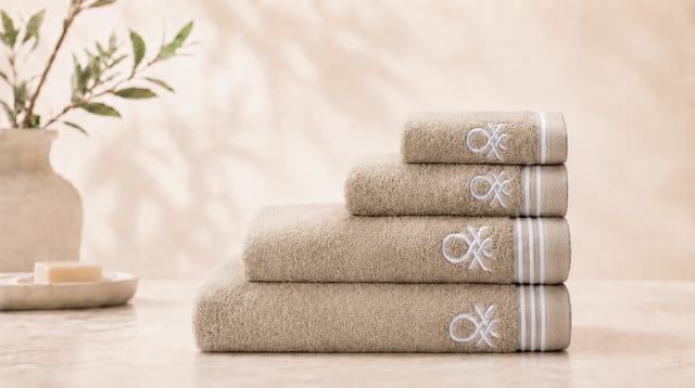 סדרת Classic Benetton, מגבות בז מקופלות עם פסים לבנים ולוגו רקום בלבן