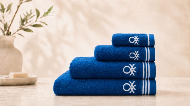 סדרת Classic Benetton, מגבות כחולות מקופלות עם פסים לבנים ולוגו רקום בלבן