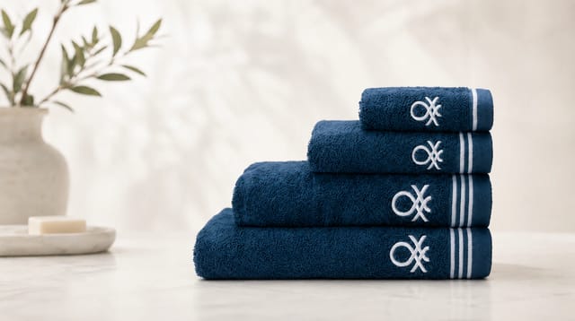 סדרת Classic Benetton, מגבות כחולות מקופלות עם פסים שחורים ולוגו רקום בשחור