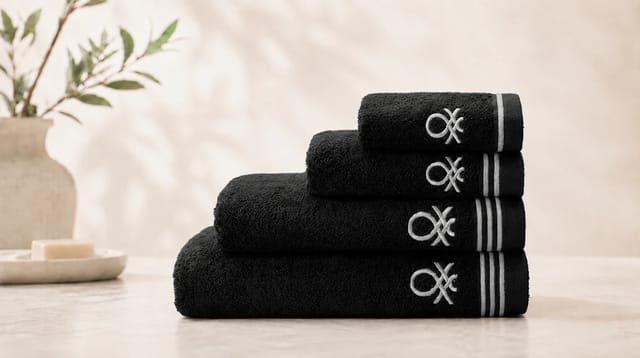 סדרת Classic Benetton, מגבות שחורות מקופלות עם פסים לבנים ולוגו רקום בלבן