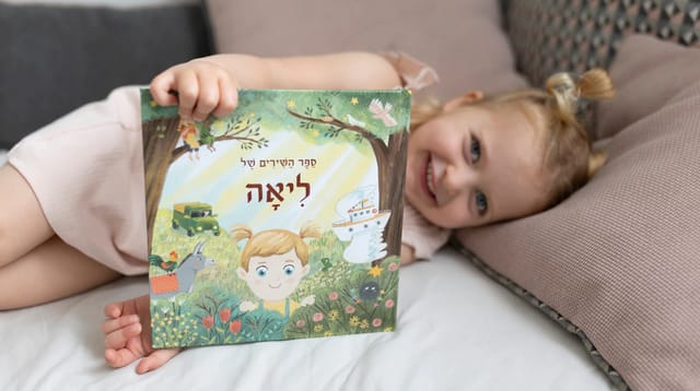 ילדה שוכבת ומחזיקה ספר של זיקית