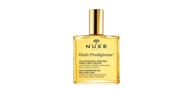 לילית קוסמטיקה - בקבוק ספריי זהוב של Huile Dry Oil Spray מבית NUXE על רקע לבן